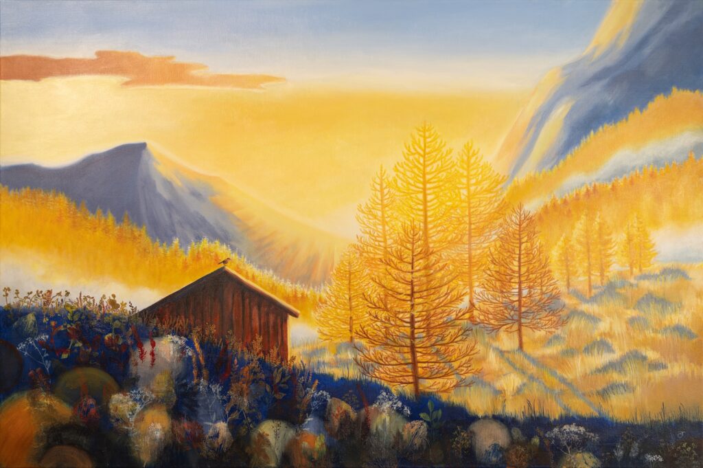 Goldene Lärchen im Abendlicht neben einer alten Holzhütte, dahinter Berge im Dunst.